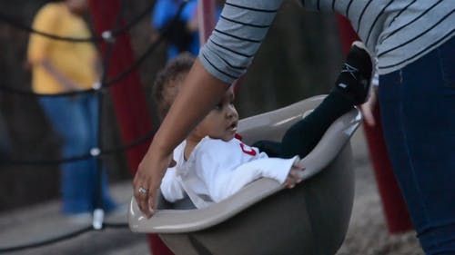 一个小女孩骑在旋转的游乐场骑 · 免费素材视频