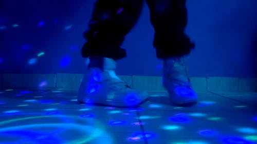 一个穿着白色运动鞋的人在迪斯科地板上显示舞步 · 免费素材视频