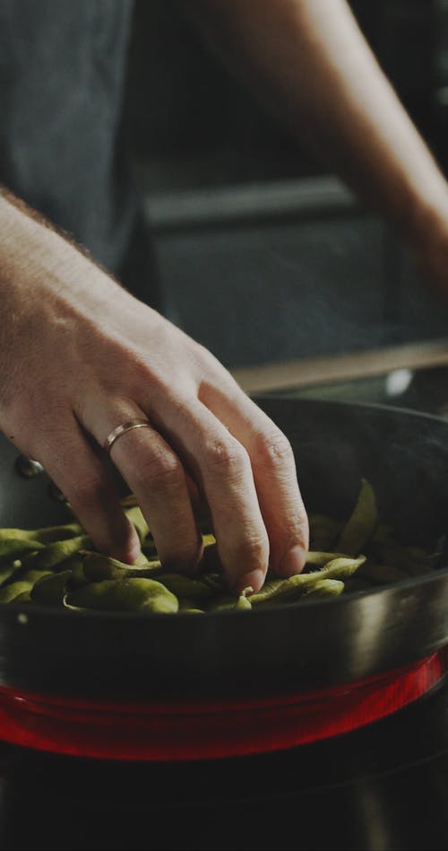厨师在热锅中触摸大豆豆荚 · 免费素材视频