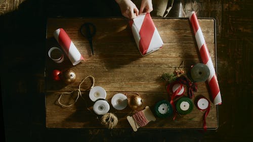 在一张木桌上包装一盒礼物的人的礼物 · 免费素材视频