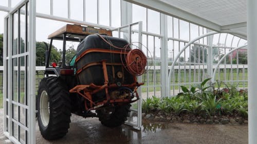 男子用拖拉机给植物浇水 · 免费素材视频