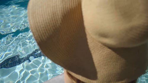 一个女人在泳衣浸洗她的脚在游泳池里 · 免费素材视频