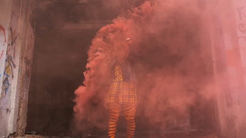 一个女人一边挥舞着烟雾弹跳舞 · 免费素材视频
