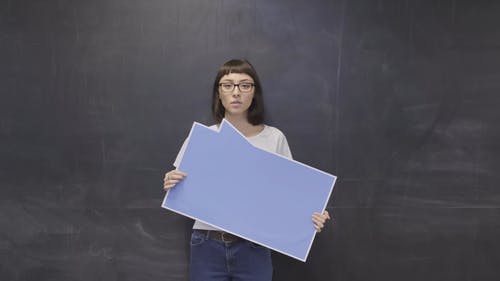 女人说话时按住一个空白的声明板 · 免费素材视频