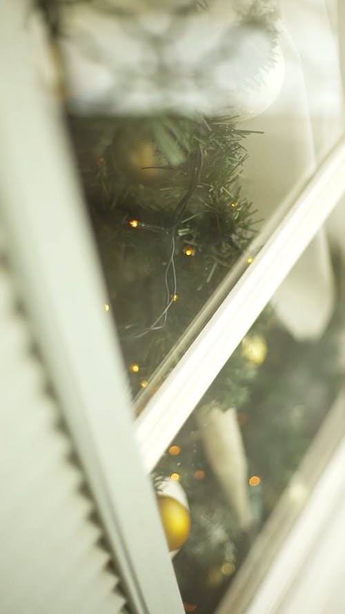 靠近窗户的一棵圣诞树的视图 · 免费素材视频