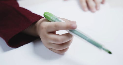 一个年轻的女孩，用着色笔在纸上画一个圆圈 · 免费素材视频