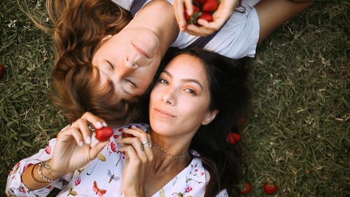 一个女人躺在草地上玩草莓 · 免费素材视频