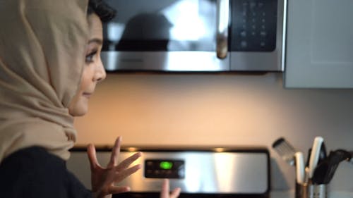 棕色盖头的女人打开煤气炉 · 免费素材视频