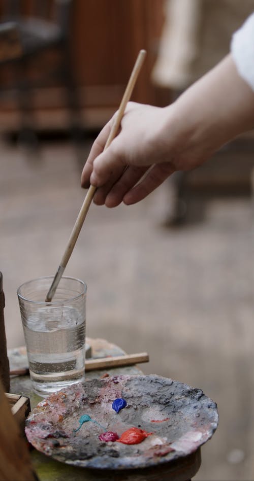 在一杯水上洗油漆刷 · 免费素材视频