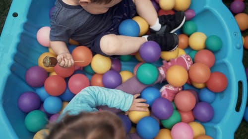 孩子们在一个装满五颜六色的球的大塑料盆上玩耍 · 免费素材视频