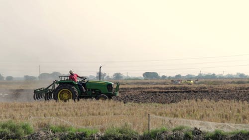 农民用拖拉机犁耕作种地的农田 · 免费素材视频