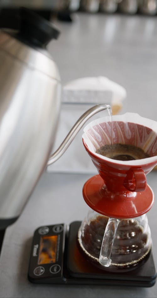 在过滤的咖啡粉杯中注入热水 · 免费素材视频