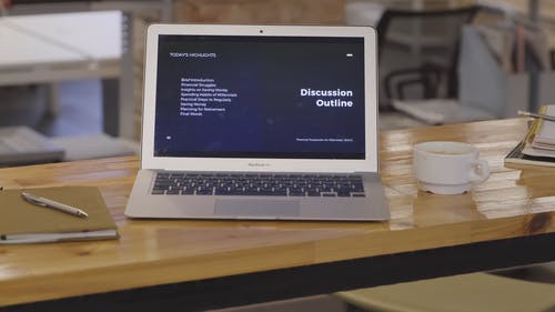 桌上的一台开放式笔记本电脑显示在工作场所处理的议程 · 免费素材视频