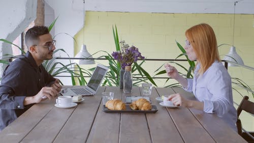 一个男人和一个女人在谈话时吃糕点 · 免费素材视频