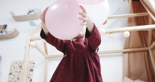 一个女孩在和她玩的气球松动 · 免费素材视频
