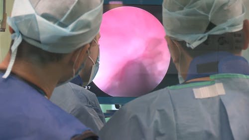 医生看着监视器在外科手术中的指南 · 免费素材视频
