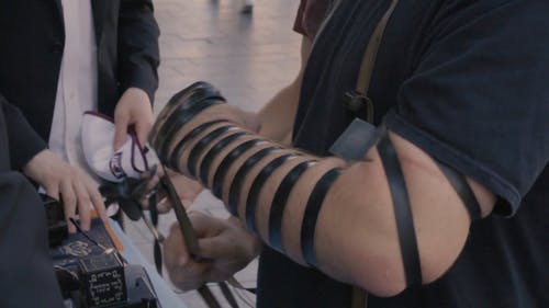 一个男人在他的手臂上缠胶带 · 免费素材视频