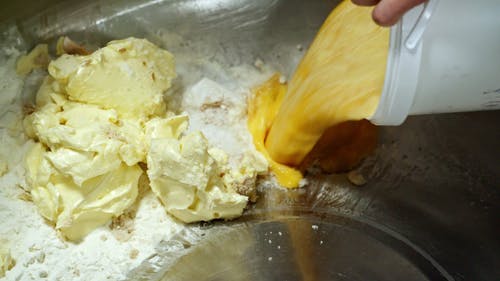 将炒鸡蛋倒入与面粉和黄油混合的搅拌器中 · 免费素材视频