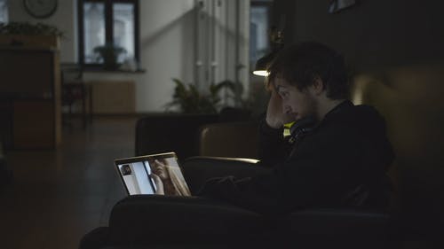 一个男人坐在视频通话的沙发上和一个使用笔记本电脑的女人 · 免费素材视频