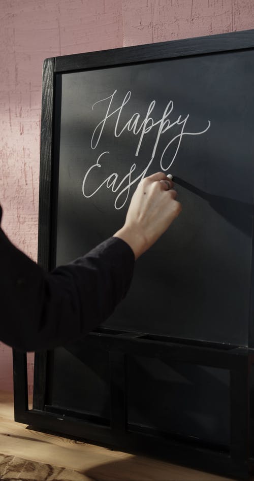 在黑板上写“复活节快乐”的问候 · 免费素材视频
