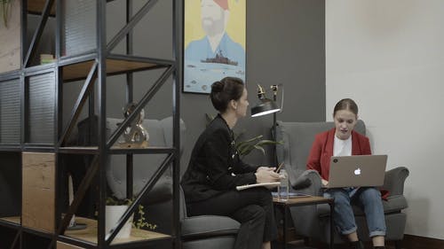 两个女人在工作时交谈，而一个男人路过 · 免费素材视频