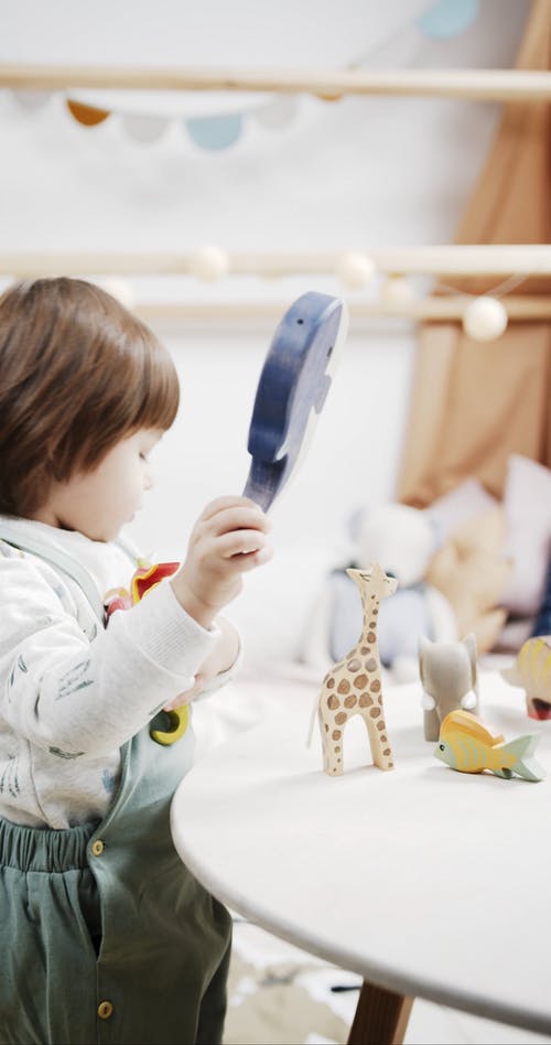 一个小女孩正忙着在桌子上玩木制玩具 · 免费素材视频