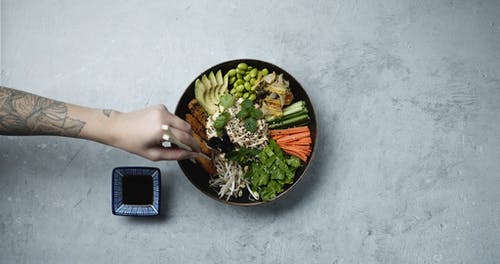 用筷子从一碗混合沙拉中蘸酱中的一种成分 · 免费素材视频