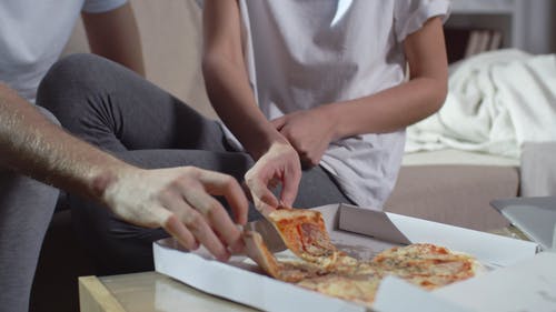 一对夫妇在客厅吃披萨 · 免费素材视频