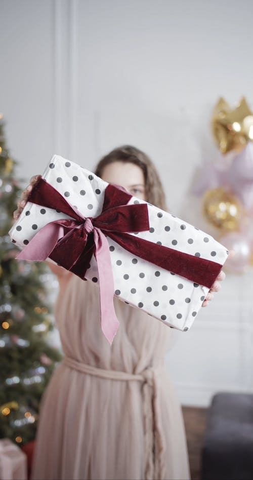 一个女人表现出用丝带包装的圣诞礼物 · 免费素材视频