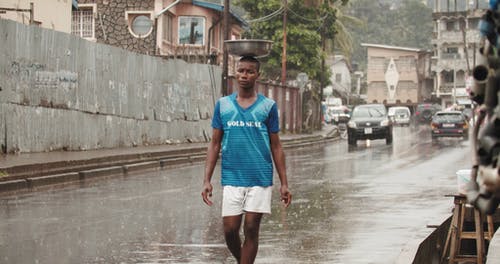 穿蓝色衬衫的男人走在雨中慢动作 · 免费素材视频