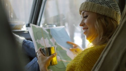 一个女人坐在一辆拿着杯子的旅行车辆的乘客侧 · 免费素材视频