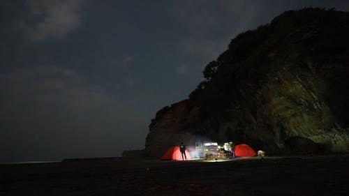人们在一座山旁边的海岸线上露营 · 免费素材视频