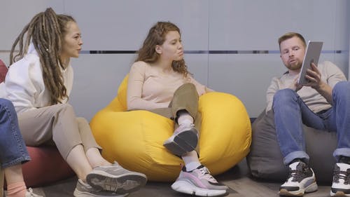 一个男人在使两个女人微笑的智能垫上显示的东西 · 免费素材视频
