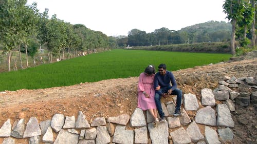 一对幸福的夫妇，在农场的无人机画面 · 免费素材视频