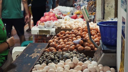 女人买鸡蛋在市场摊位 · 免费素材视频