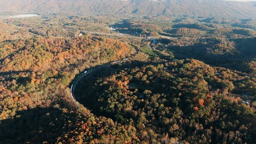 一列火车在树和山旁边行驶的鸟瞰图 · 免费素材视频