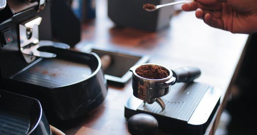 一名调酒师，将咖啡粉压在咖啡机的滤杯上 · 免费素材视频