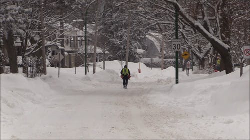 一个人在积雪覆盖的路上行走 · 免费素材视频