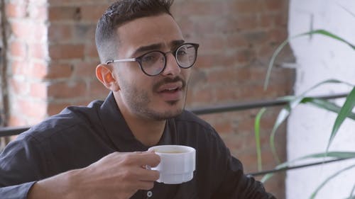 一个男人一边聊天一边喝咖啡 · 免费素材视频