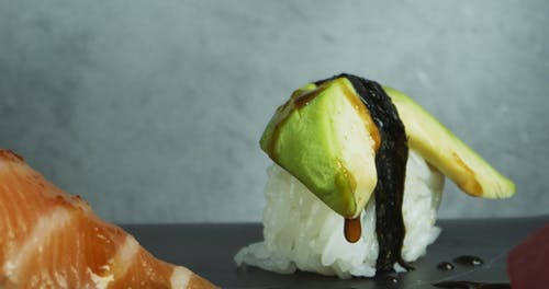 在混合寿司上撒芝麻 · 免费素材视频