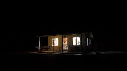 一所孤立的房子的灯光使它在夜晚的黑暗中可见 · 免费素材视频