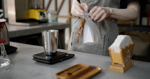 在锡杯中倒入新鲜咖啡豆并称重 · 免费素材视频