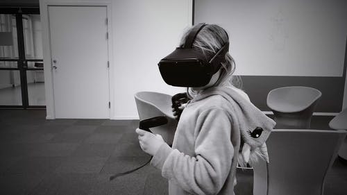 小女孩在玩时戴虚拟现实耳机 · 免费素材视频