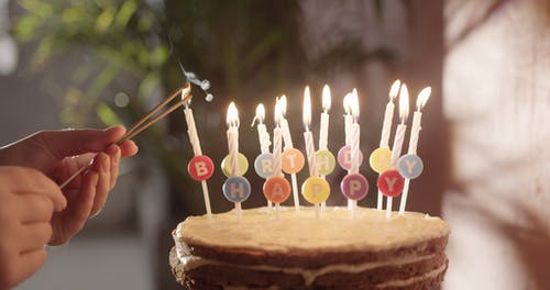 从生日蛋糕的蜡烛上点燃手持式烟火 · 免费素材视频