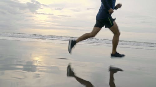 一个人在海滩海岸线上奔跑 · 免费素材视频
