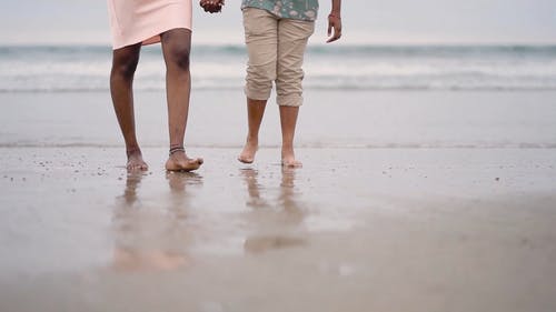 一对情侣在沙滩上散步 · 免费素材视频