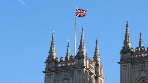 一幢带有罗马建筑设计与屋顶上的英国国旗的低角度镜头 · 免费素材视频