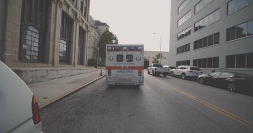 一辆停在街上的救护车，上面有紧急闪光灯 · 免费素材视频