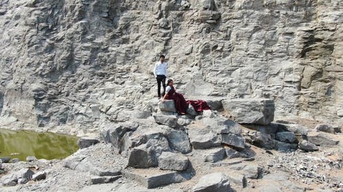 一对夫妇在使用无人机的岩石上的画面 · 免费素材视频