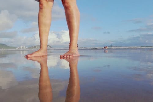 脚倒在湿的海边上的倒置图像 · 免费素材视频